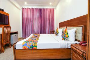 - une chambre avec un grand lit, une commode et une fenêtre dans l'établissement SKS Excel Inn, à Gurgaon