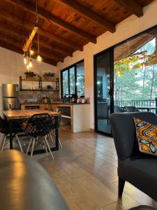 a kitchen and living room with a table and chairs at Cabaña El Encanto in Mazamitla