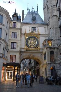 a building with a large clock on the side of it at Hotel Les Arcades in Rouen