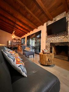sala de estar con sofá y chimenea en Cabaña El Encanto en Mazamitla