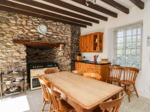 eine Küche mit einem Holztisch und einer Steinmauer in der Unterkunft Dewi Villa in Aberaeron