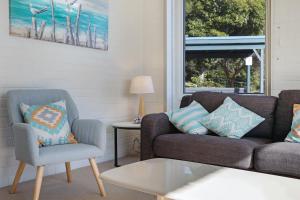 a living room with a couch and a chair at Calendo Apartments in Merimbula