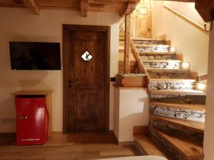 uma escada numa casa com uma porta de madeira em La Maison. Il Nido dell'Aquila em Bardonecchia