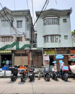 マニラにあるBudget Transient Capsule Room Makati near Ayala and Buendiaの建物前に停車する一団の二輪車