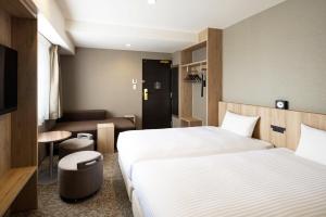 a hotel room with two beds and a desk at the b namba-kuromon in Osaka