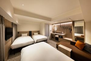 a hotel room with two beds and a couch at the b namba-kuromon in Osaka