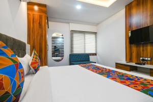 a hotel room with a bed and a tv at FabHotel Stay Well in Indore
