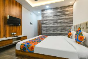 ein Schlafzimmer mit einem großen Bett und einem TV in der Unterkunft FabHotel Stay Well in Indore