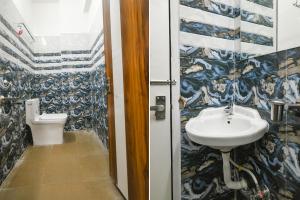 ein Bad mit einem Waschbecken und einem WC in der Unterkunft FabHotel Stay Well in Indore