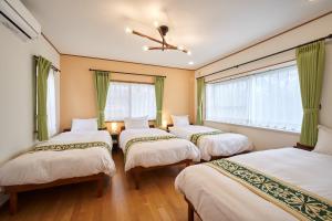 3 camas en una habitación con ventanas en S-villa Nasu Blanca, en Nasu