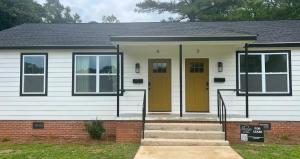a house with a yellow door and stairs at Modern 2 Bedroom Apartment in Monroeville