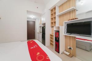1 dormitorio con 1 cama grande con alfombra roja en RedLiving Apartemen Transpark Juanda - Frams Properti Tower Jade with Netflix, en Bekasi