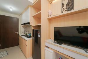 cocina con TV de pantalla plana grande en una habitación en RedLiving Apartemen Transpark Juanda - Frams Properti Tower Jade with Netflix, en Bekasi