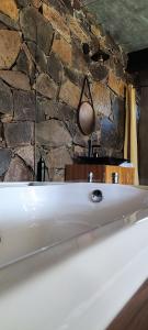La salle de bains est pourvue d'une baignoire et d'un mur en pierre. dans l'établissement Cabañas San Marcos, à Mazamitla