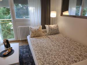 a small bedroom with a bed in front of a window at Apartman TEO, self check-in, free parking in Slavonski Brod