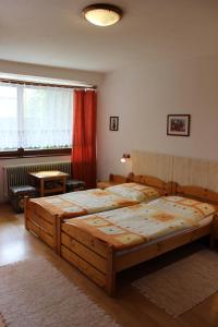 a bedroom with two twin beds and a window at Penzión Mária in Smižany