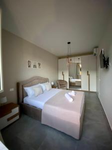 a bedroom with a large bed and a living room at APPARTAMENTO IL MARE in Marina di Massa