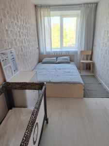 sypialnia z 2 łóżkami i oknem w obiekcie Dzintaru apartamenti w mieście Mērsrags