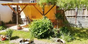 a backyard with a wooden pergola and some plants at Ferienwohnung Bänsch in Weischlitz
