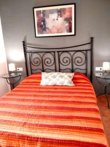 ein Schlafzimmer mit einem Bett mit einer orangefarbenen Bettdecke in der Unterkunft 4 bedrooms villa with private pool enclosed garden and wifi at Bellvei 6 km away from the beach in Bellvei del Penedes