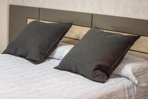 una cama con dos almohadas encima en The Clock Tower Apartment, en Jaén