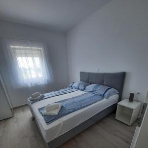 a bedroom with a large bed with a window at Apartments Matkovic in Vir