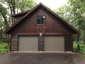 un garaje con una puerta de garaje y una casa en Welcome to Lookout Estates, en Cross Lake