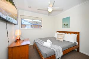 een kleine slaapkamer met een bed en een raam bij Maroochydore 3 B/R, 2 Bath, Townhouse ZA4 in Maroochydore