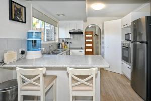 a kitchen with a counter and two stools at Maroochydore 3 B/R, 2 Bath, Townhouse ZA4 in Maroochydore