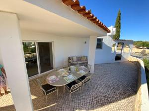 un patio con tavolo e sedie sul balcone. di Villa Luisa with private pool and amazing views ad Alcantarilha