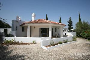 une petite maison blanche avec un toit dans l'établissement Villa Luisa with private pool and amazing views, à Alcantarilha