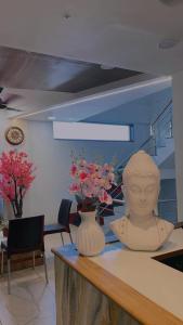 a vase sitting on a counter with a statue on it at HOTEL VENUS in Veraval