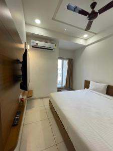 a bedroom with a bed and a flat screen tv at HOTEL VENUS in Veraval