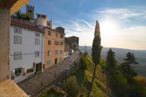 a group of buildings on a hill with the sun in the sky at Bella Vista Apartments in Motovun