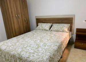 a bedroom with a bed and a wooden cabinet at Apartamentos en el Norte de cali in Cali