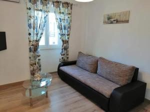 ein Wohnzimmer mit einem Sofa und einem Glastisch in der Unterkunft Apartments Martina in Banjole