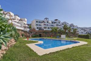 una piscina frente a un gran edificio en 2-bedroom apartment with seaview, en Nerja