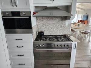 een keuken met een fornuis en een magnetron bij Seaside Tresure. in Mosselbaai