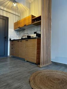 a kitchen with wooden cabinets and a rug on the floor at Thea comfy living in Nea Vrasna