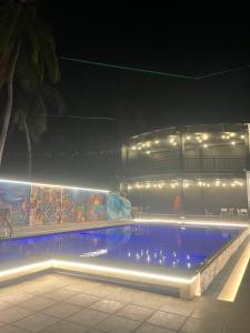 a swimming pool with lights in front of a building at Aurora Banquet and Hotel in Chilaw