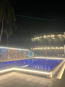una piscina con luces frente a un edificio en Aurora Banquet and Hotel, en Chilaw