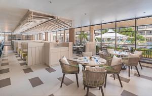 a restaurant with tables and chairs and windows at Henann Park Resort in Boracay