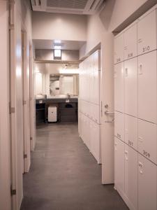 a long hallway with white cabinets and a kitchen at ELE Cabin Shinjuku Kabukicho in Tokyo