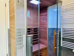 una sauna con puerta de cristal en una habitación en Parkvillen Carlota und Candela Baabe, en Baabe