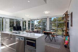 cocina abierta con sala de estar y comedor en Husqi Loft, en Huskisson