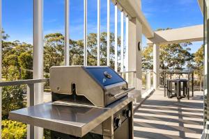 una parrilla en el porche delantero de una casa en Husqi Loft, en Huskisson