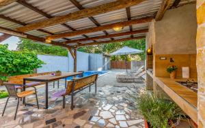 a patio with a table and chairs under a pergola at Villa Iness Medulin in Medulin