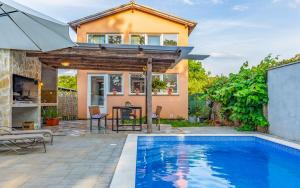 a home with a swimming pool and a house at Villa Iness Medulin in Medulin