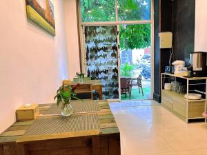um quarto com uma mesa com um vaso com uma planta em Hotel Baya Phuket em Praia de Patong