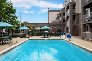 una piscina con mesas, sillas y sombrillas en Residence Inn by Marriott Salt Lake City Downtown, en Salt Lake City